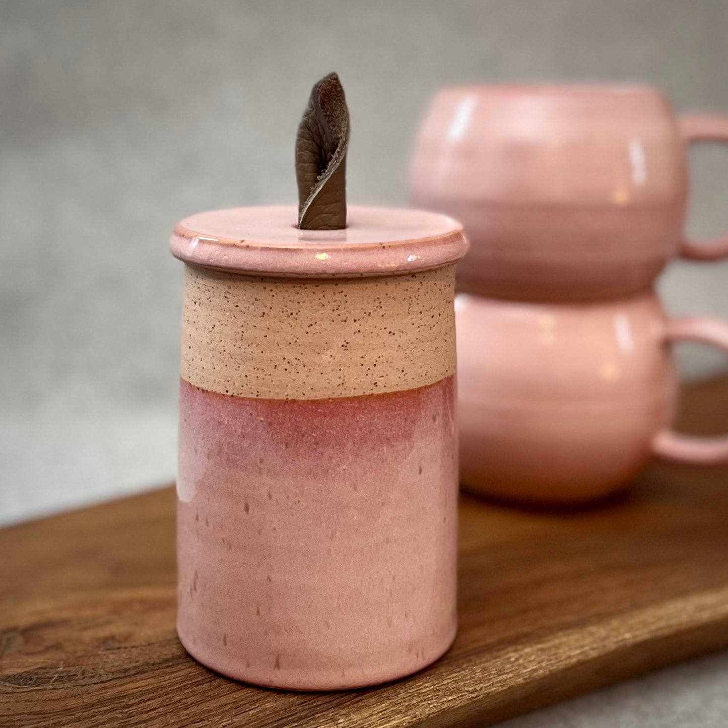 creamy pink lidded jar with leather handle