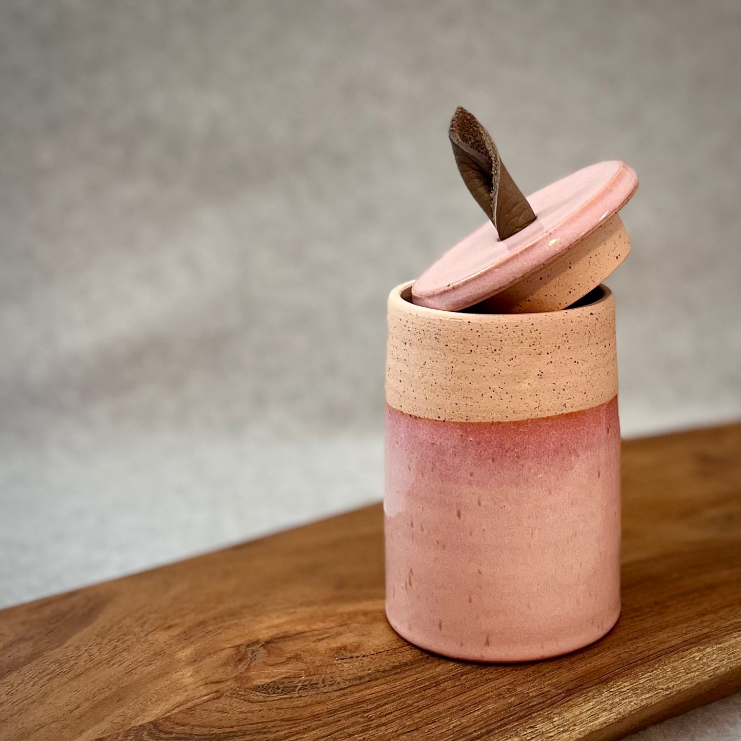 creamy pink lidded jar with leather handle