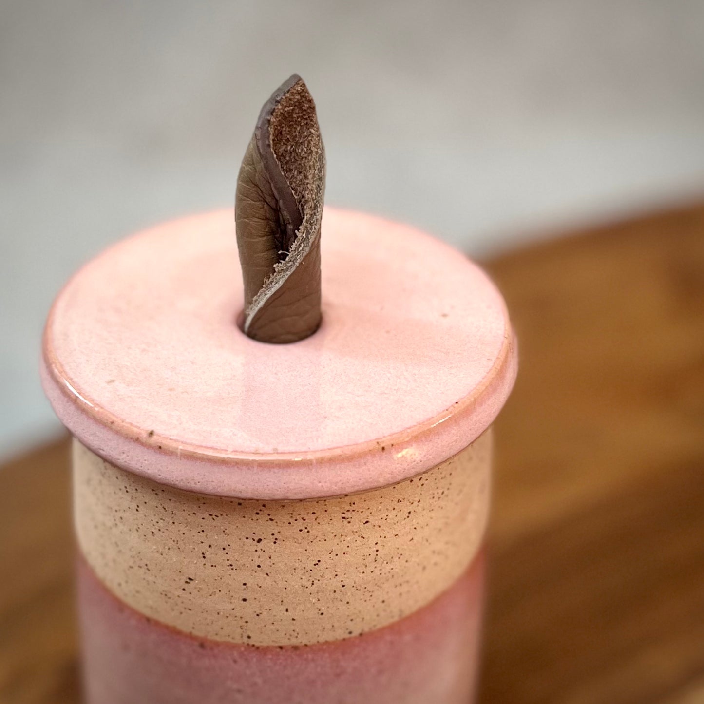 creamy pink lidded jar with leather handle